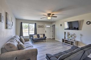 a living room with two couches and a flat screen tv at Pet-Friendly Bullhead City Abode with Game Room in Bullhead City
