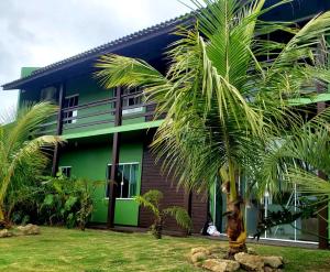 a house with a palm tree in front of it at Morada Flores de Alaíde - Pinheira in Pinheiro