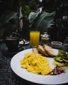 a plate of eggs and toast and a glass of orange juice at El Albergue Ollantaytambo in Ollantaytambo