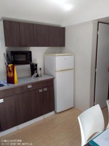 uma cozinha com armários castanhos e um frigorífico branco em mobil home 001 em Agde