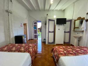 a room with two beds and a tv in it at Cabañas y Flores in Jericó