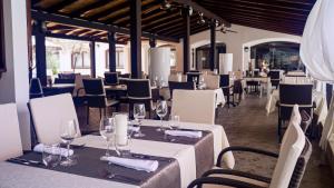 a restaurant with tables and chairs with wine glasses at Hotel Villa Letan in Fažana