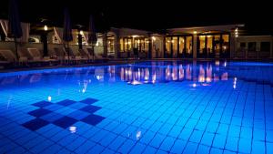 a large swimming pool at night with blue lighting at Hotel Villa Letan in Fažana