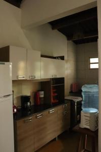 a kitchen with wooden cabinets and a white refrigerator at Casa Recanto das Mangueiras Japaratinga - Alagoas in Japaratinga