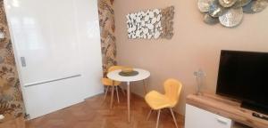 プラハにあるアパートメント ヤクブスカー 676のテーブルと椅子、テレビが備わる客室です。