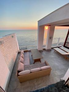 Sala de estar con sofá, mesa y el océano en Luxury Penthouse with Full Sea View, en Durrës