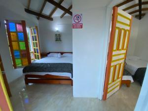 - une chambre avec un lit et des portes en verre teinté dans l'établissement Cabañas y Flores, à Jericó