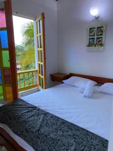 a bedroom with a bed and a large window at Cabañas y Flores in Jericó