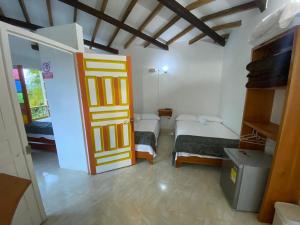 a room with two beds and a door at Cabañas y Flores in Jericó