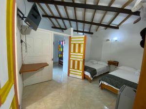 Zimmer mit 2 Betten und einem TV. in der Unterkunft Cabañas y Flores in Jericó