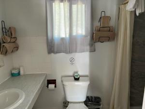 uma casa de banho com um WC branco e um lavatório. em El Portal Motel em Beatty