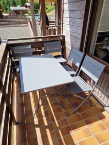 Studio le Grand-Bornand Village في لو غراند بورناند: طاولة بيضاء وكراسي على شرفة