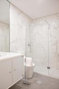 a white bathroom with a shower and a toilet at Byobu Apartment, by Bolhão Residences in Porto