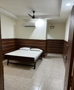 a bedroom with a bed and a ceiling fan at HOTEL THILAK in Tuticorin