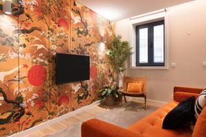 uma sala de estar com uma televisão na parede em Byobu Apartment, by Bolhão Residences em Porto