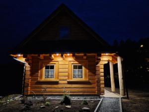 uma pequena cabana de madeira com luzes acesas à noite em Chabrowa Chatka em Ustroń