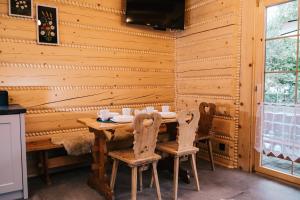 a wooden dining room with a wooden table and chairs at Chabrowa Chatka in Ustroń
