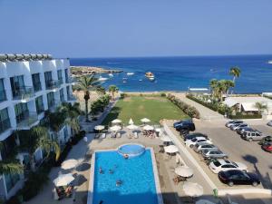 uma vista aérea de um resort com uma piscina e o oceano em Dess Dream Vacation 1 bedroom Flat steps from Da Costa Bay, Protaras em Protaras