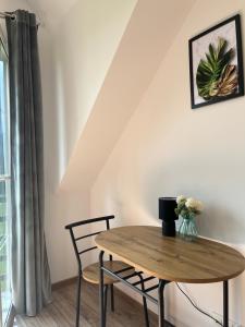 a table and chairs in a room with a window at Agroturystyka Liana in Polanica-Zdrój