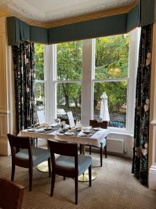 a dining room with a table and a large window at Ascot House in Harrogate