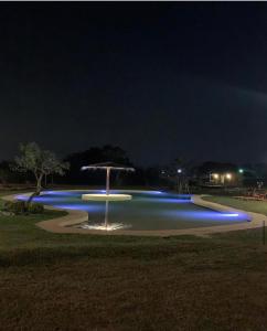 ein Pool mit blauen Lichtern in einem Park in der Nacht in der Unterkunft Cabañas Alba in Nueva Italia