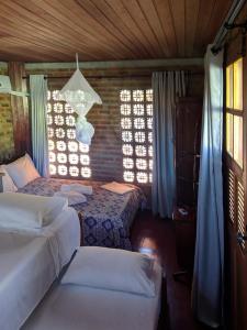 a bedroom with two beds and a chandelier at Chalés na Hora in Olinda