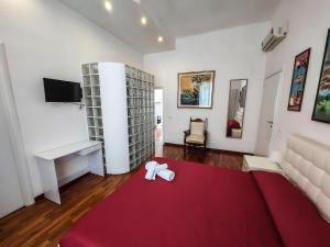 a living room with a red rug and a room with a tv at Casa Flora in Taranto