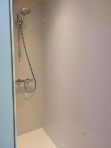 La salle de bains est pourvue d'une douche avec un pommeau de douche. dans l'établissement Geniet van alle comfort tussen Ieper en Heuvelland, à Ypres