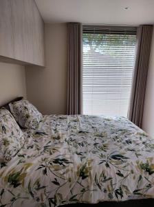 a bedroom with a bed and a window with a comforter at Geniet van alle comfort tussen Ieper en Heuvelland in Ieper