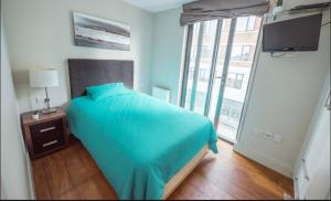 a bedroom with a blue bed and a window at Fantastic 3 bedrooms flat in Euston Zone 1 in London