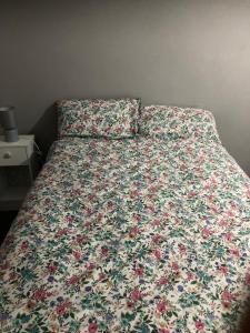 a bed with a floral comforter on it in a bedroom at Worthing bright and cosy double room in Worthing