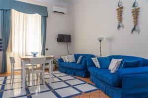 ein Wohnzimmer mit einem blauen Sofa und einem Tisch in der Unterkunft My Place Apartment in Castellammare di Stabia