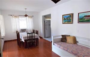 een woonkamer met een tafel en een eetkamer bij Casa a uma quadra da praia in Maresias