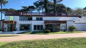 a large white house with a lot of windows at Hotel Los Pinos Country in Punta del Este