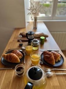 uma mesa coberta com pratos de pastelaria e sumo de laranja em Appartement T2 - Vue imprenable sur la cathédrale em Quimper