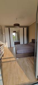1 dormitorio con 1 cama y suelo de madera en La maison de Florina en Milán