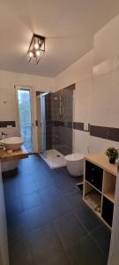 een badkamer met 2 wastafels, een bad en een douche bij La maison de Florina in Milaan