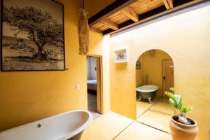 a bathroom with a bath tub and a mirror at Hotel Los Amantes in Oaxaca City