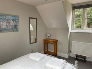 a bedroom with a bed and a mirror and a table at Coach House Mews in Stratford-upon-Avon