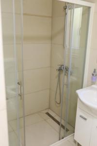 a shower with a glass door next to a sink at Soba KONAK 4 in Jajce