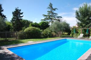 a blue swimming pool in a yard at Hôtel Le Barry, Toulouse Nord in Gratentour
