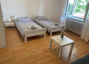ein Wohnzimmer mit 2 Betten und einem Tisch in der Unterkunft Apartmaji Amitis in Portorož