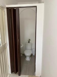 a bathroom with a toilet and a door open at Apartamento con aire acondicionado y parqueadero por dias en Santa Marta in Santa Marta