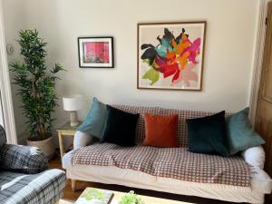 a living room with a couch with colorful pillows at Elegant Bloomsbury Apartment in Tunbridge Wells in Royal Tunbridge Wells