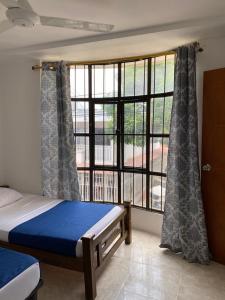 a bedroom with a bed and a large window at Apartamento con aire acondicionado y parqueadero por dias en Santa Marta in Santa Marta