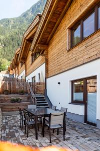 a patio with a table and chairs and a building at Alp Apart in Oetz