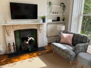 uma sala de estar com lareira e uma televisão por cima em Elegant Bloomsbury Apartment in Tunbridge Wells em Royal Tunbridge Wells
