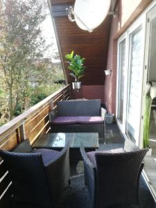 Un patio con sillas y una mesa en el balcón. en Küstensonne, en Esens