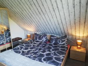 1 dormitorio con 1 cama con edredón azul y 2 lámparas en Küstensonne, en Esens