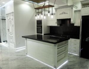 a kitchen with white cabinets and a black counter top at Everything for you in Samarkand